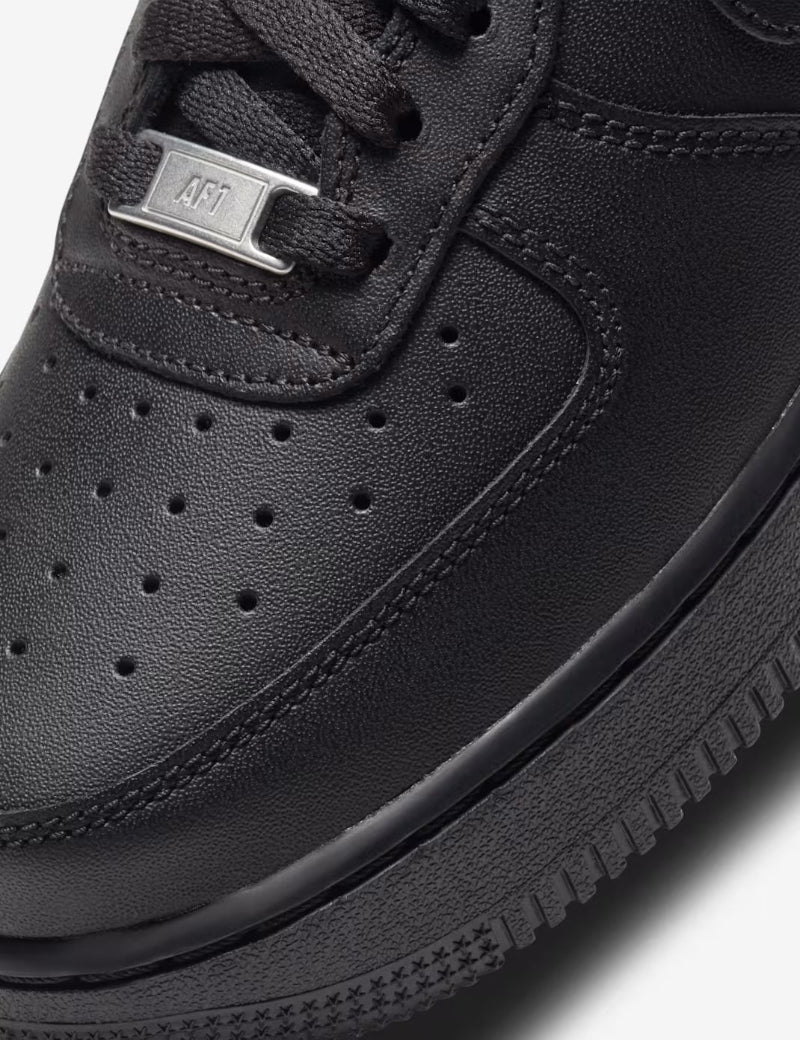 Close-up of a black sneaker with a focus on the sole and brand logo.
