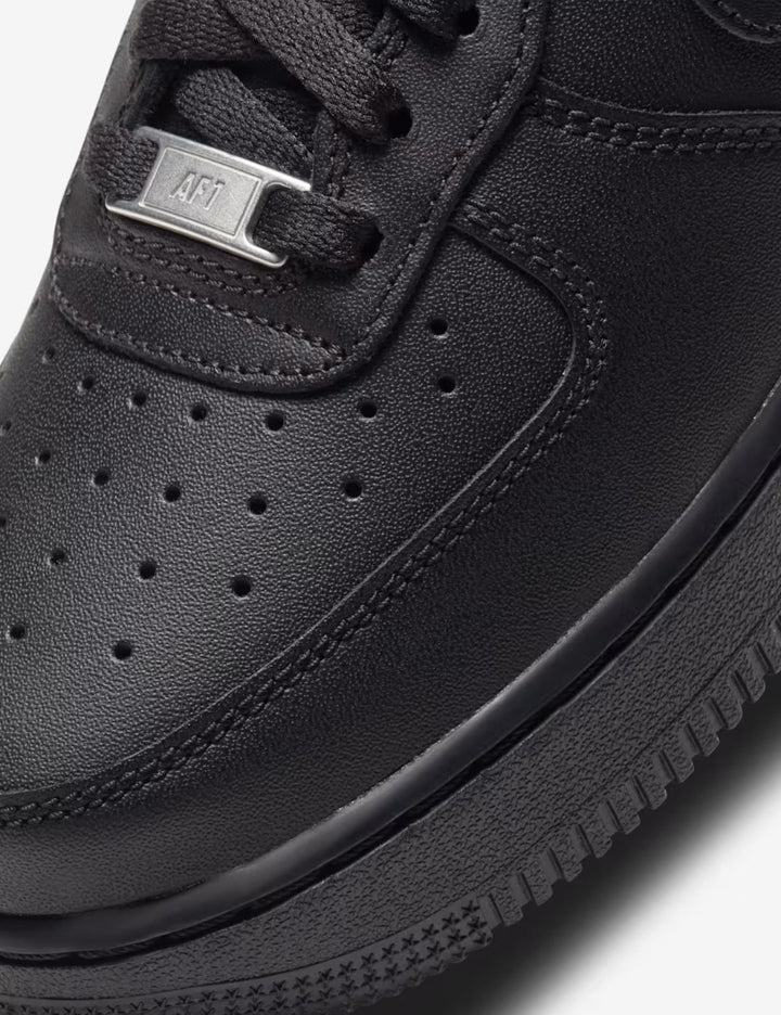 Close-up of a black sneaker with a focus on the sole and brand logo.