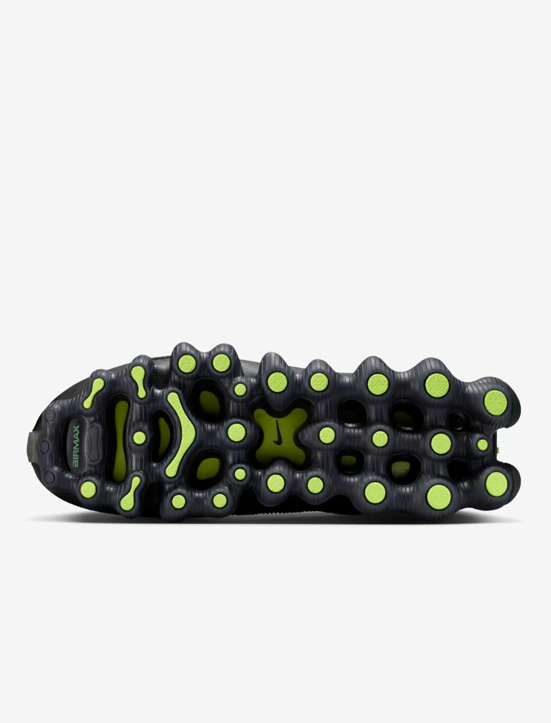 Close-up of a black shoe sole with green accents on a white background