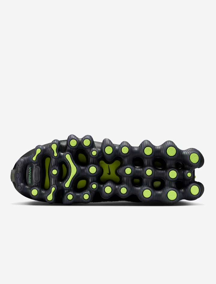 Close-up of a black shoe sole with green accents on a white background