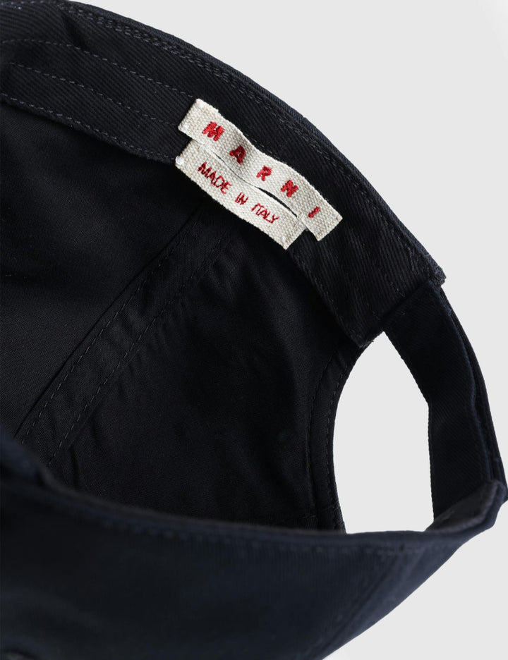 Black cap with a label on a light gray background